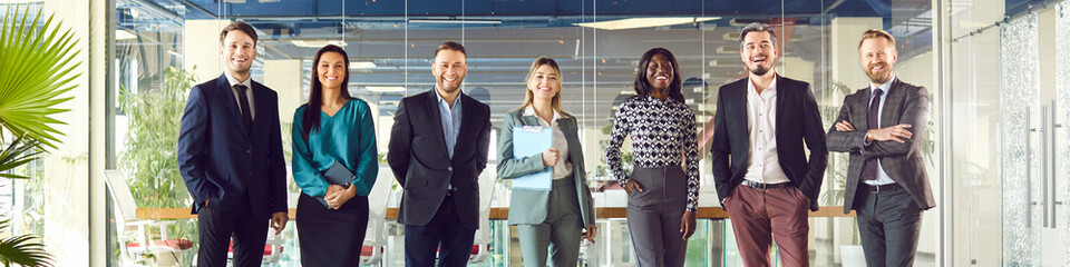 Group of business multiethnic people men and women looking cheerful at camera and smiling standing...