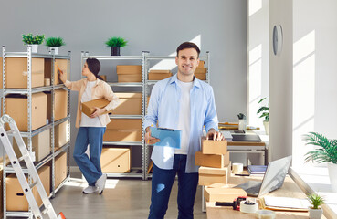 E commerce business workers. Online store employees work in warehouse storage room. Happy male...