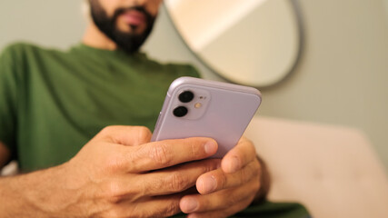 Close-up of a young man's hands holding a mobile phone, focus on smartphone