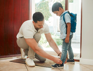 Father, tying shoes and school with son by door for morning preparation or getting ready at home. Dad, child or tie laces with kid for education, learning journey or first day at preschool at house