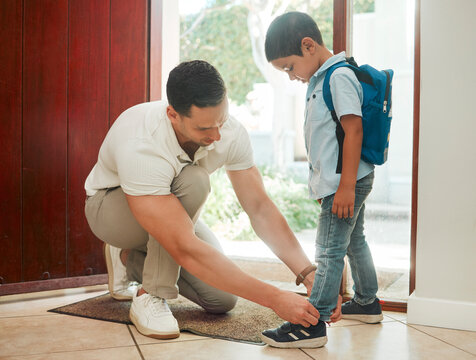 Father, tying shoes and school with son by door for morning preparation or getting ready at home. Dad, child or tie laces with kid for education, learning journey or first day at preschool at house