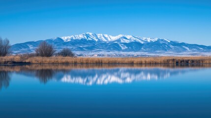 Snow capped mountains reflected in tranquil blue water