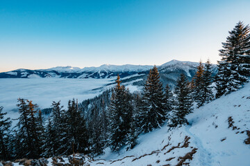 Winter hiking to Sina in Low Tatras National park near jasna is full of beautiful views. Sunset in Slovakia mountains with Chopok peak.