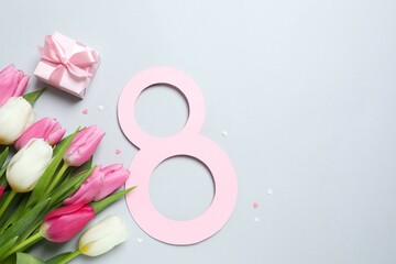 8 March greeting card design with tulip flowers and gift box, top view. Happy International Women's Day