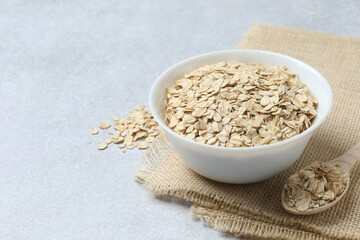 Composition with oatmeal flakes on gray background. Cooking breakfast