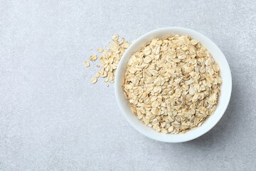 Composition with oatmeal flakes on gray background. Cooking breakfast