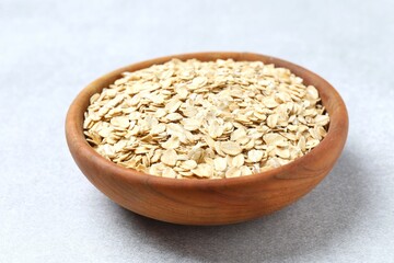 Composition with oatmeal flakes on gray background. Cooking breakfast