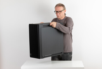 Man holding a heavy PC case, weight 15,8 kg, empty big tower, chassis.