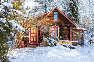 rural log house on snowy yard in village in winter