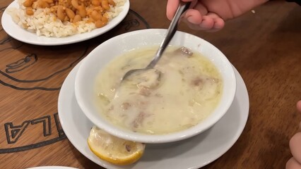 A Savory Turkish Lamb Soup, Garnished with Lemon and Served with Rice and Beans