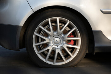 Sunset light shines on a deflated car tire on a road.