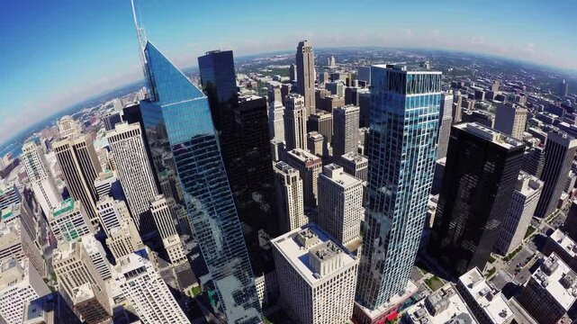 Comcast technology center and center city district are rotating, showcasing philadelphia's modern architectural landscape and urban density under a clear blue sky