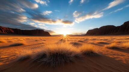 A stunning golden sunrise breaks over a vast desert landscape, illuminating the foreground with soft light and casting shadows on the distant rock formations.