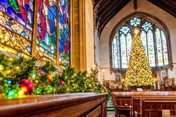 Obraz premium Church interior with Christmas tree, garland decor and stained glass, copyspace