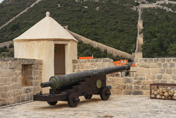 Historical cannon, in the town of Ston, Croatia. There are stone cannonballs lying next to it. Clouse-up