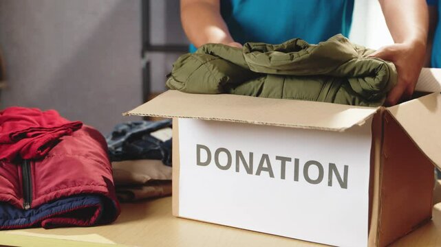 Volunteers engaging in the sorting and packing of reusable clothing donations. Ensuring that usable items are ready for distribution to those in need. Clothing donations, social impact, volunteer