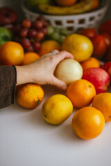 Woman's hand picking fresh fruit from a colorful assortment in the kitchen