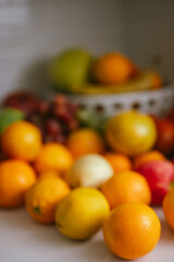  Assorted fresh fruits arranged on a kitchen counter with a basket with blurred background