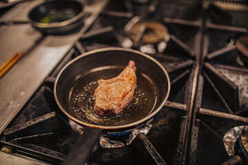  A large lamb chop meat cooking in frying pan with oil 