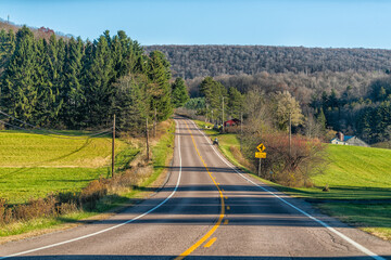 West Virginia rural countryside road highway by agricultural pasture field rolling hill landscape in autumn fall with tractor driving in Canaan Valley