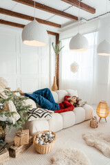 a woman in the Christmas decorated rom with a spruce tree ms Santa