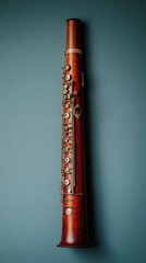 A beautifully crafted vintage bass clarinet with intricate metal keys displayed on a striking blue backdrop showcasing elegant wood grain detailing