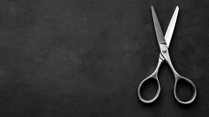 Hairdressing shears on dark surface, copy space