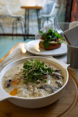 Savory Oatmeal with Mushrooms and Poached Egg in Café Setting
