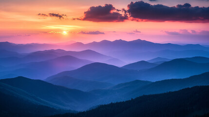 Obraz premium A breathtaking sunset paints the sky in pink and orange hues above rolling blue mountain ranges, creating a peaceful scene