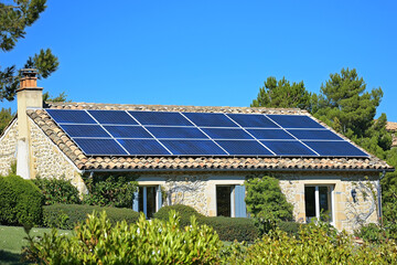 Rooftop solar panels on a traditional French house under blue sky
