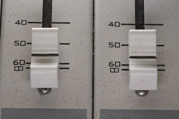 2 slider pots on an audio mixing board, very dusty