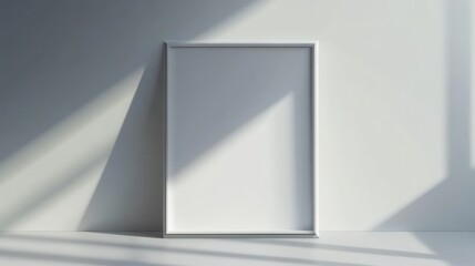 Empty picture frame with shadows on minimalistic white wall in bright sunlight
