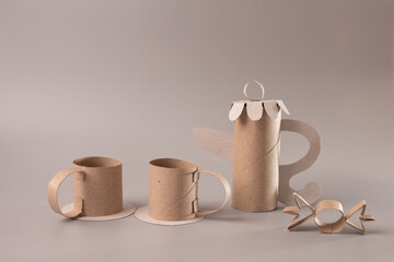Toilet paper rolls on table, still life with cardboard teapot, miniature product shot, coffee cups, children, elegant design, product introduction,