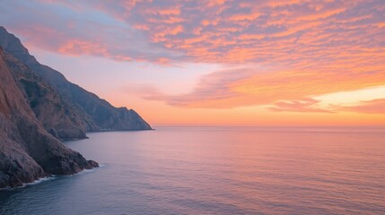 Obraz premium Serene Sunset Over Rocky Coastline and Calm Sea