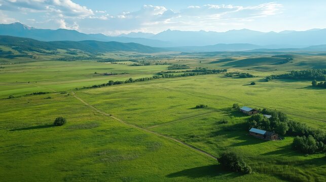 Aerial View of Serene Green Field and Mountain Range