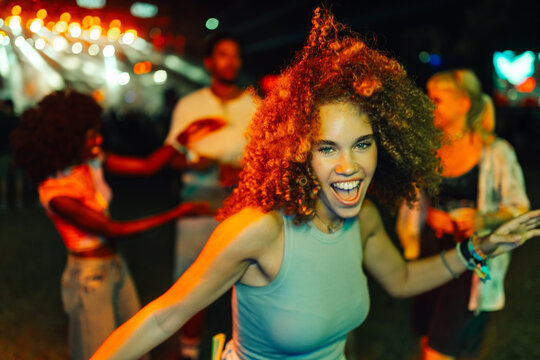 Young woman dancing and enjoying music festival at night