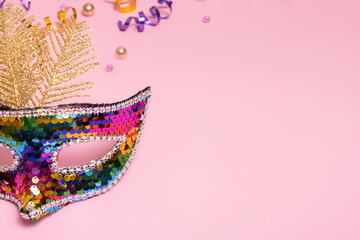 Colourful festive face mask for carnival celebration on colored background. Copy space