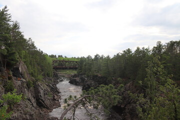 Rapid water from a waterfall underneath the pedestrian bridge at Jay Cooke State Park, Minnesota	