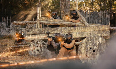 Group of people in full gear playing paintball on shooting range
