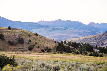 Mountain hills and green valley bathed in glow after sunset