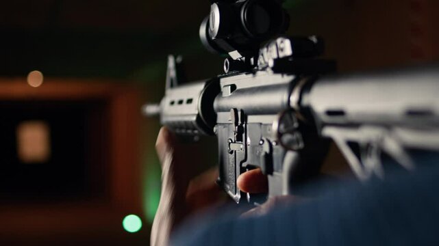 Man holds assault rifle, enjoying recreational shooting experience in firing range. Person practices with semiautomatic weapon in safe environment at shooting range company, camera A extreme close up