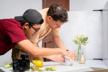 Photographers preparing scented candles for product photography in studio