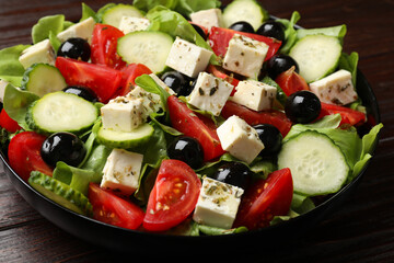 Delicious salad with feta cheese on wooden table, closeup