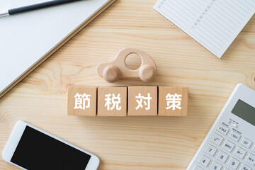節税対策と書かれたブロック、電卓、スマホ、車のおもちゃ