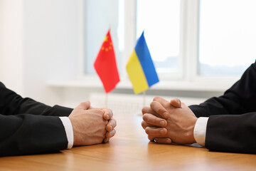 Diplomats negotiating during meeting at wooden table indoors, closeup