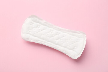 Menstrual pad on light pink background, top view