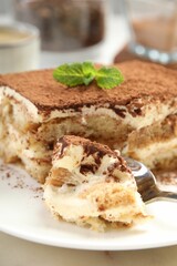 Piece of tasty tiramisu on table, closeup