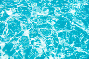 Water background, ripple waves. Blue swiming pool pattern. Sea surface. Water in swimming pool with sun reflection. Banner with copy space.