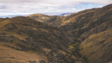 Beautiful mountainous hill landscape central otago new zealand yellow grass low clouds dramatic sky 