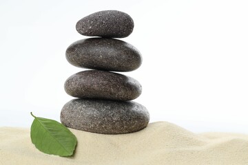 Stack of rocks on sand against white background. Harmony and life balance